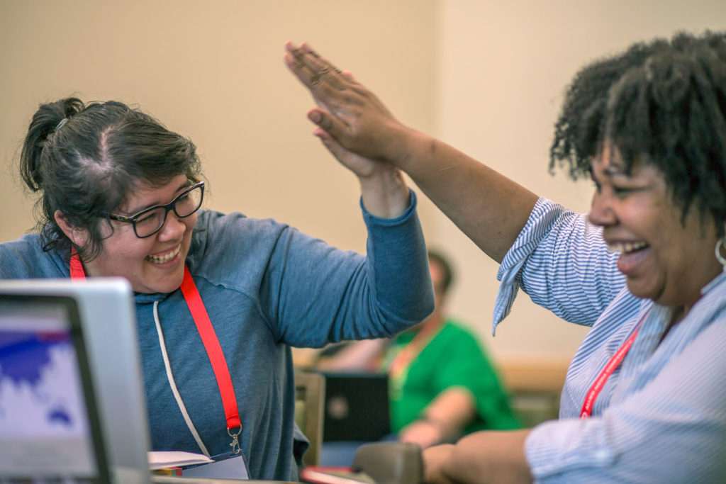 Two seated participants high-fiving